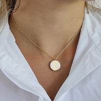 a 14k gold filled necklace with a handmade white porcelain pendant with 24k gold kintsugi pendant